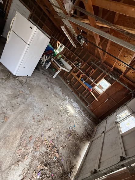Garage cleared out after junk removal, with just a refrigerator remaining