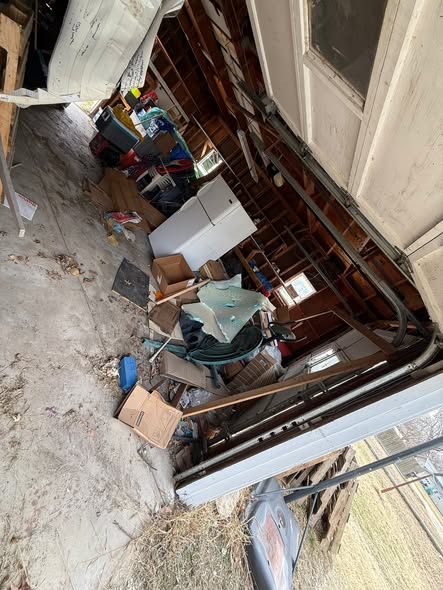 Garage packed floor to ceiling with boxes and clutter before cleanout
